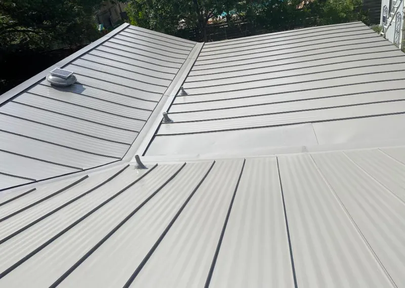 Solar attic fan installed on a metal roof for Roof Ventilation in Ames